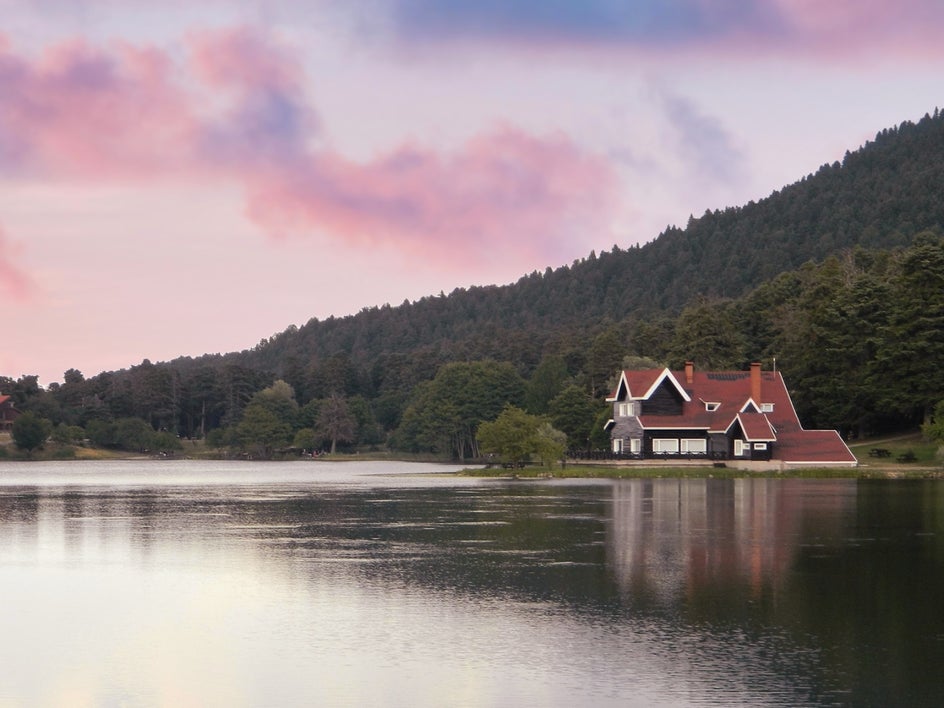 pink and pastel sky applied to make the lakefront home look romantic