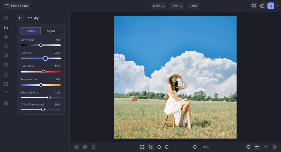 The image now includes a vibrant blue sky with fluffy clouds. The Sky Replacer’s Settings panel is open on the left, showing sliders for contrast, saturation, edge lighting, and affect foreground adjustments.